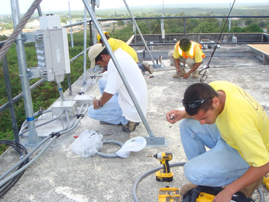 Technicians mounting Flexi-conduits on the roof of the Days Inn site