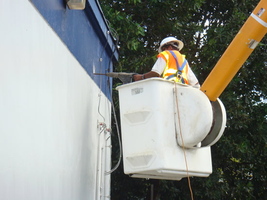 Gibson site in Tamuning; Techs drilling exterior wall for Cable port entry