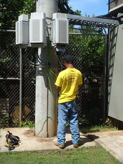 Technician working on radio grounds at the Yona site